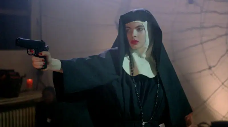 A woman dressed as a nun holding a gun in a tense scene from Revenge Horror! : Episode 210.