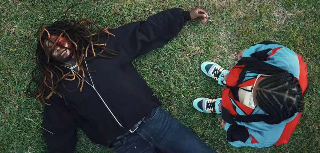 A horror-themed scene with a person lying on the grass with a creepy mask, and a child looking down,.