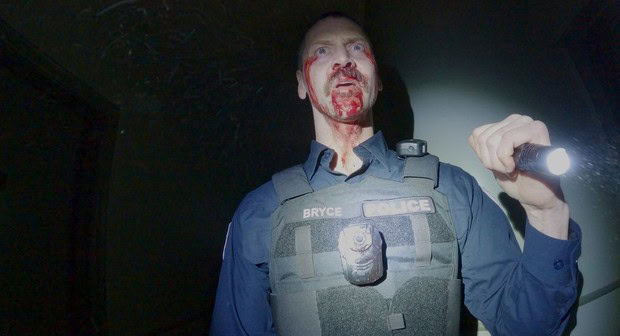 A terrifying police bodycam footage of a bloodied officer in a dark setting.