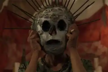 A haunting figure wearing a skull mask with spikes, evoking fear and unease.