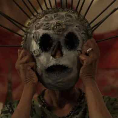 A haunting figure wearing a skull mask with spikes, evoking fear and unease.