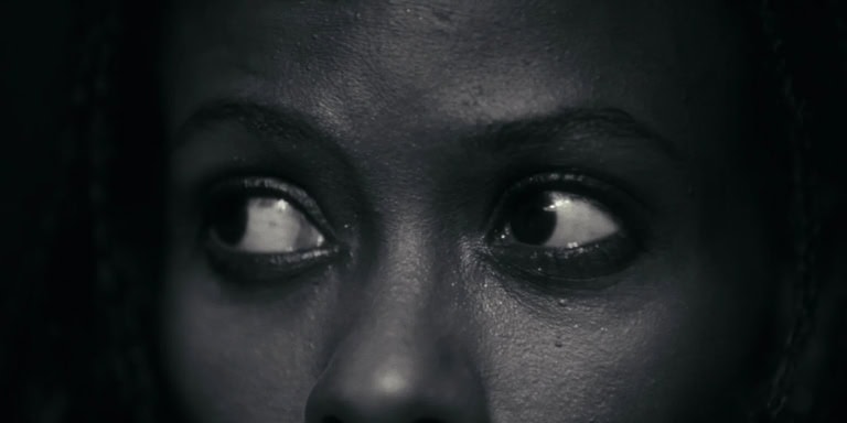 A haunting close-up of a person's eyes with a dark, eerie atmosphere.