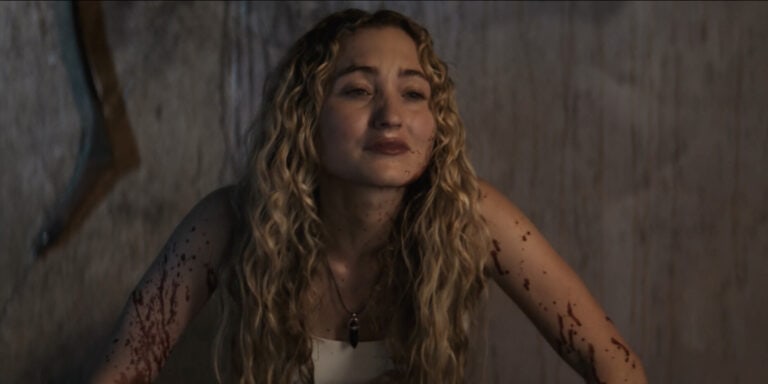 A haunting woman with bloodstained hands and a sinister expression.