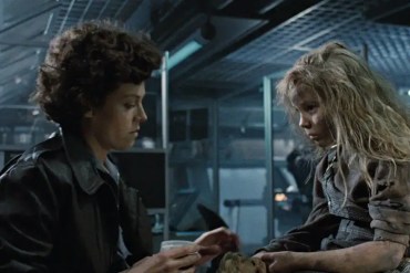 A woman and a girl with disheveled hair in a dark, industrial setting, appearing tense and distresse.