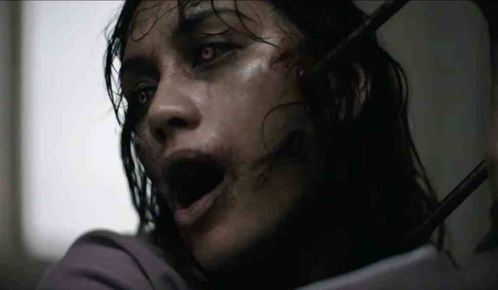 A terrifying close-up of a possessed woman with dark, disheveled hair and a haunting expression from.