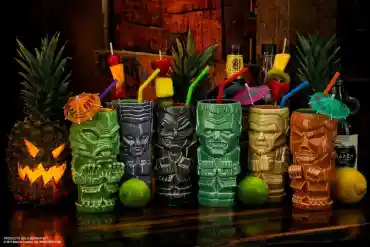 A colorful collection of tiki mugs with tropical drinks and umbrellas at Crypticon Seattle 2026.