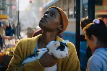 A woman holding a black and white cat at a street market during Crypticon Seattle 2026: Pets In Horr.
