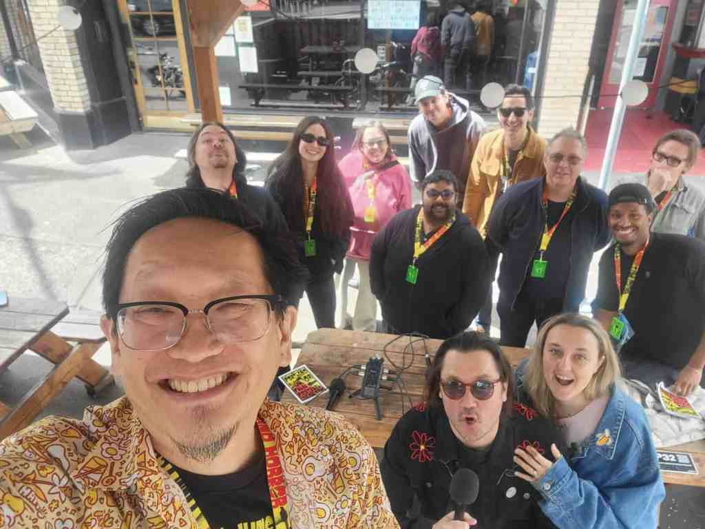 Group of diverse filmmakers at a film festival, smiling and posing for a selfie.