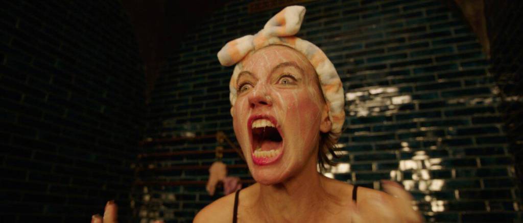 Woman with a headscarf screams in a dark, tiled room for a horror film scene.