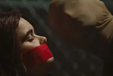 Disturbing woman with red tape over mouth, dark background, horror scene, fear, suspense, thriller i.