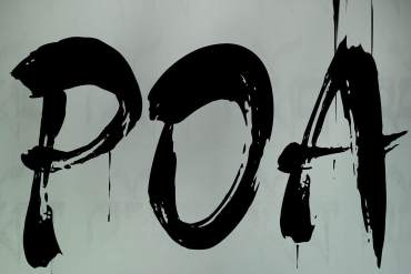 Eerie black graffiti spelling "POA" on a gray wall with dripping paint.