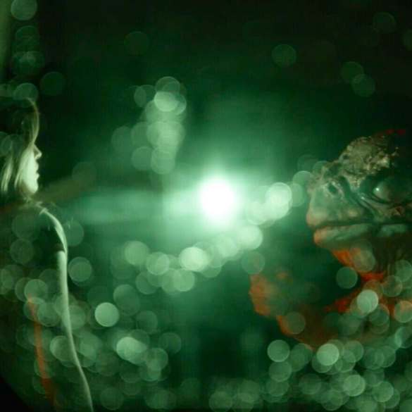 Futuristic scene with glowing green lights and a mysterious figure in darkness.