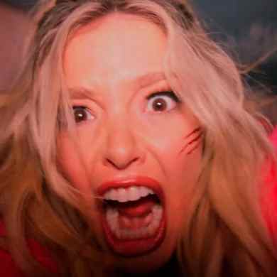 Woman with blonde hair screaming with a frightened expression and scratches on her face.
