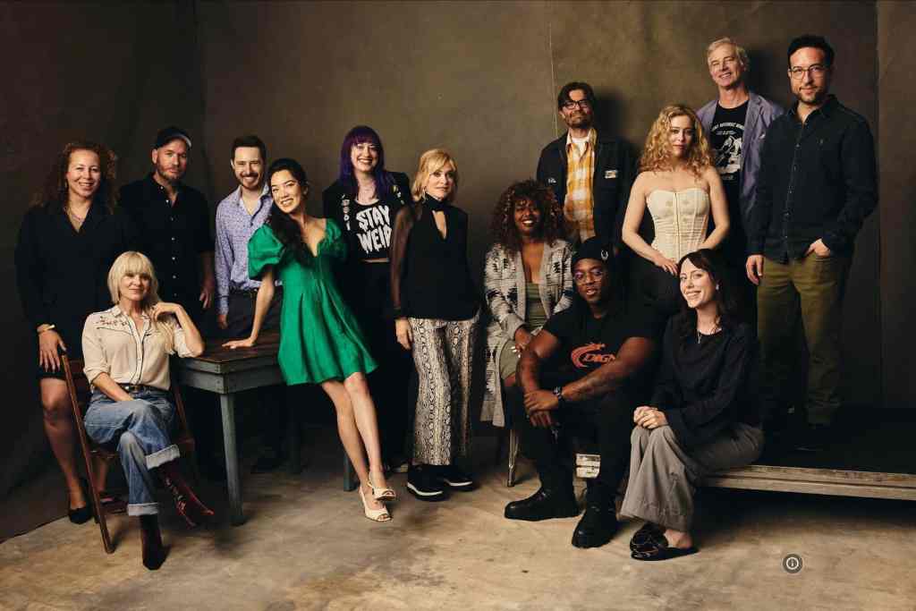 Group of diverse people in a studio, smiling and posing for a photo.