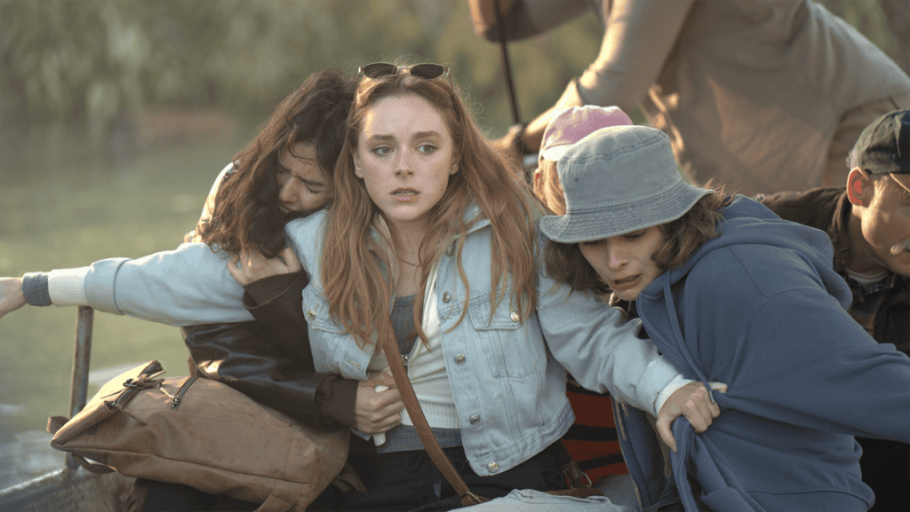 Young women on a boat look surprised and scared during a daytime outdoor trip.