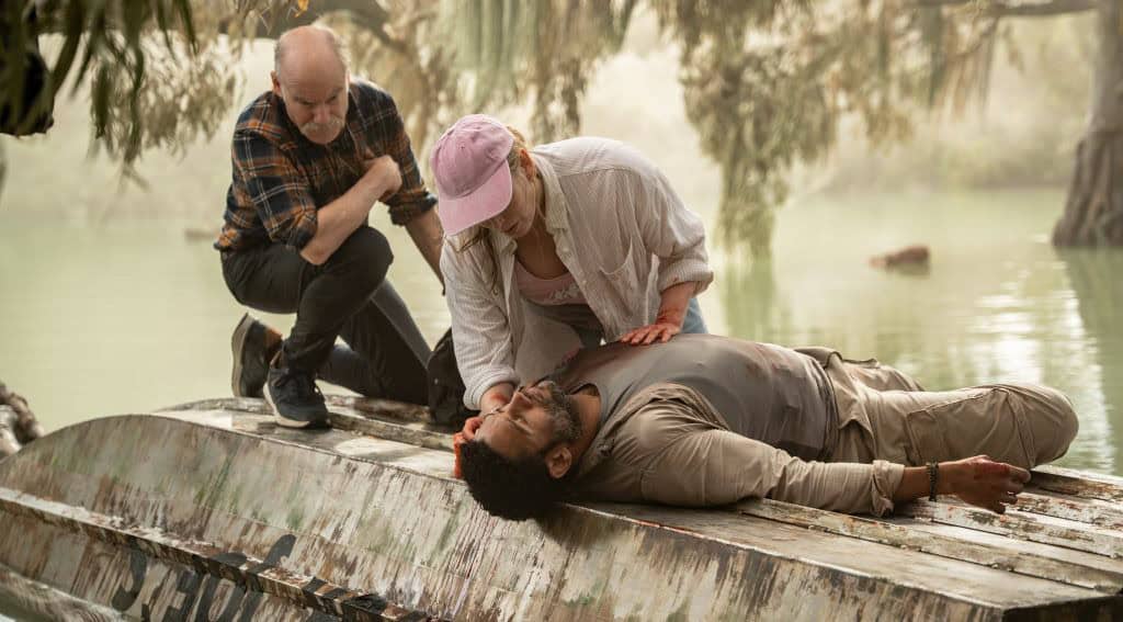 Scene from 'Hungry' 2026 with characters on a boat in a swampy area.
