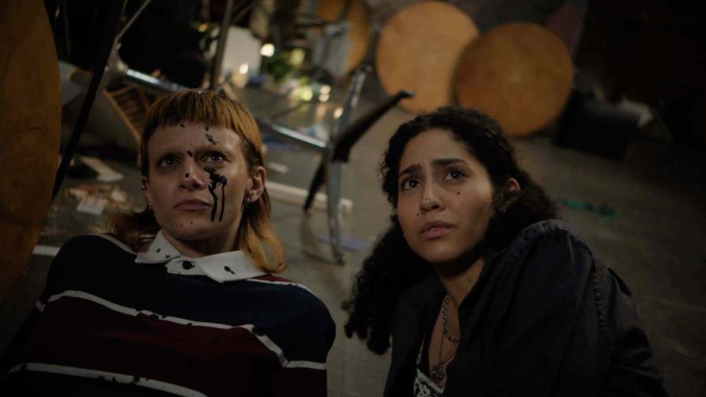 Two women with distressed expressions in a dimly lit room.