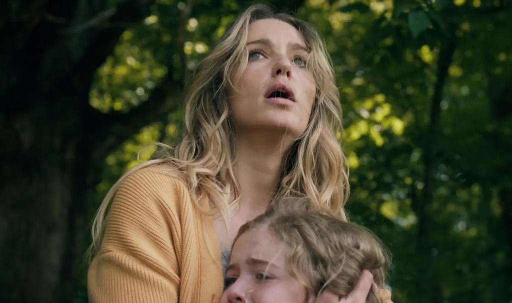 Woman and child in a forest, looking up with concern and fear.