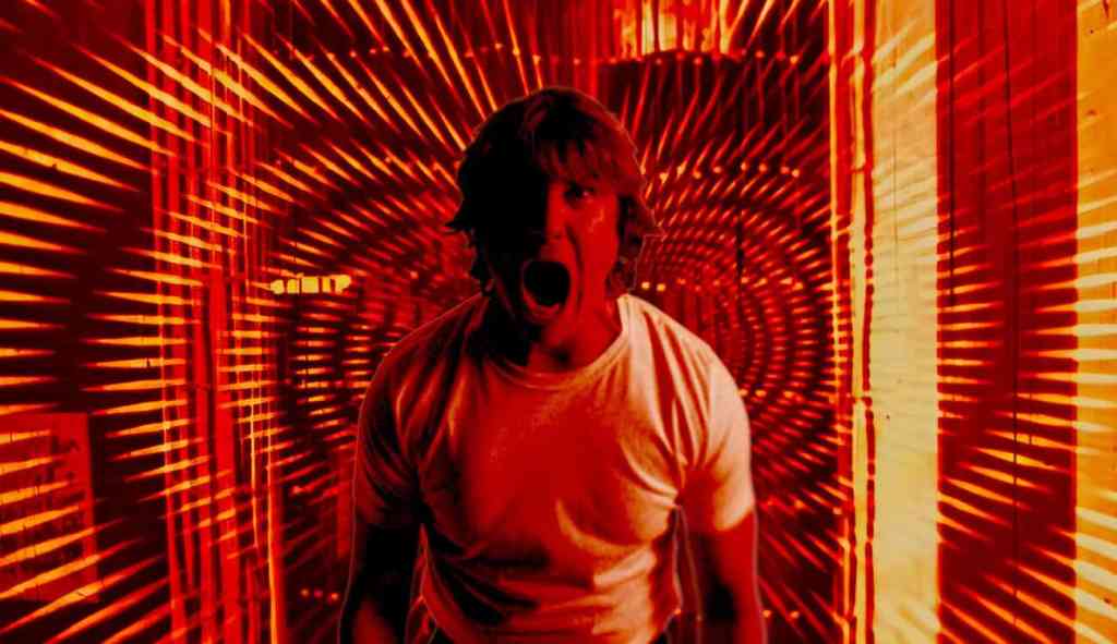 Scared man in a tunnel of red and orange light effects.