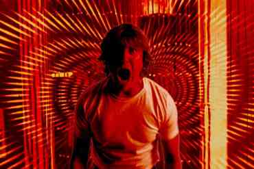 Scared man in a tunnel of red and orange light effects.