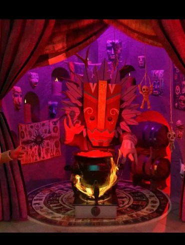 Colorful puppet show scene with a sinister puppet and stage curtains.