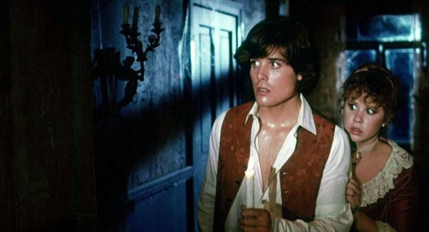 Two women look frightened in a dark, eerie room with blue lighting.