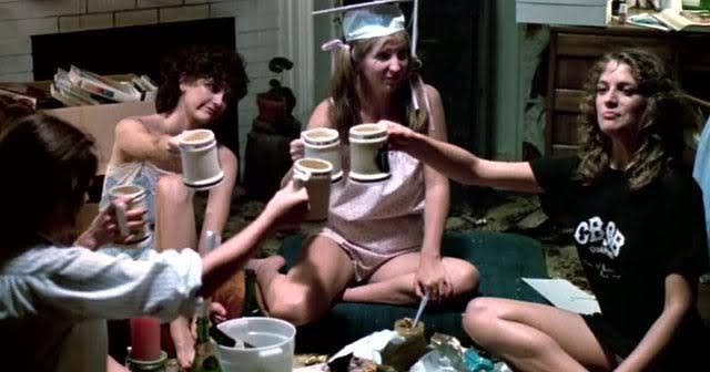 Group of young women having a casual party with drinks in a cozy living room.