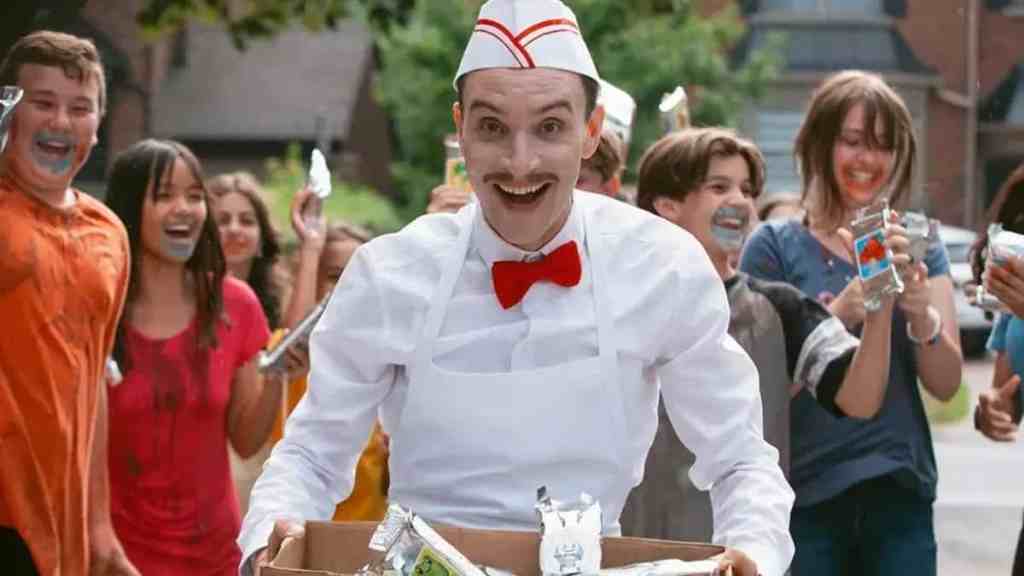 Ice cream man in costume with children enjoying ice cream outdoors.