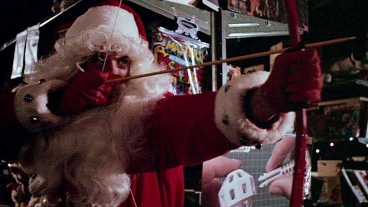 Santa Claus aiming a bow and arrow in a comic horror scene.