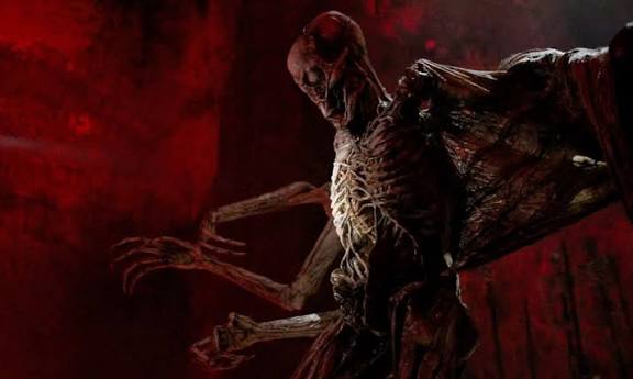 Eerie alien creature with skeletal features in a dark, ominous setting.