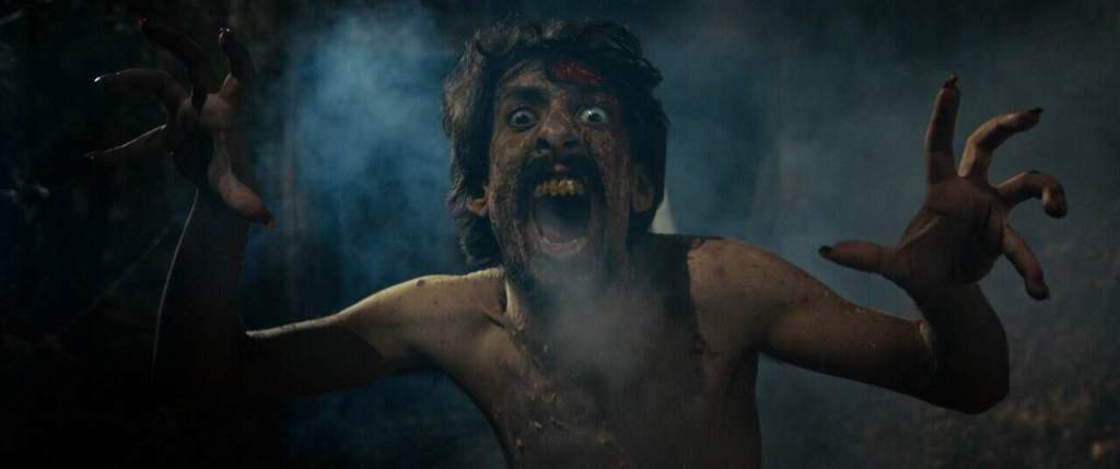 Scary creature with wild hair and intense expression in a dark, smoky setting.