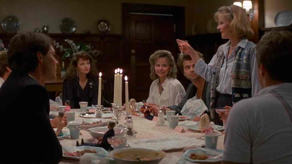 Family gathered around a dinner table with candles, celebrating a special occasion.