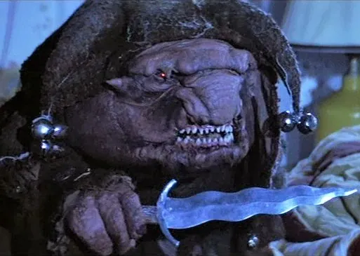 Scary creature with a sword, wearing a hood, in a horror scene.