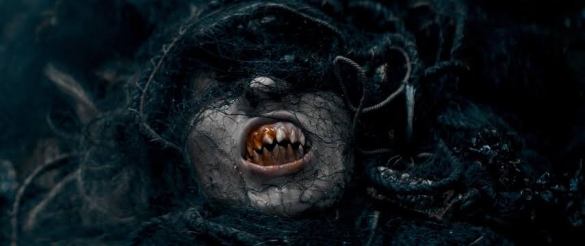 Scary creature with decayed face and sharp teeth, dark and eerie atmosphere.