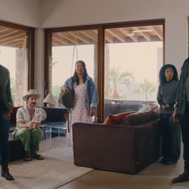 Diverse group of five people in a modern living room with large windows.