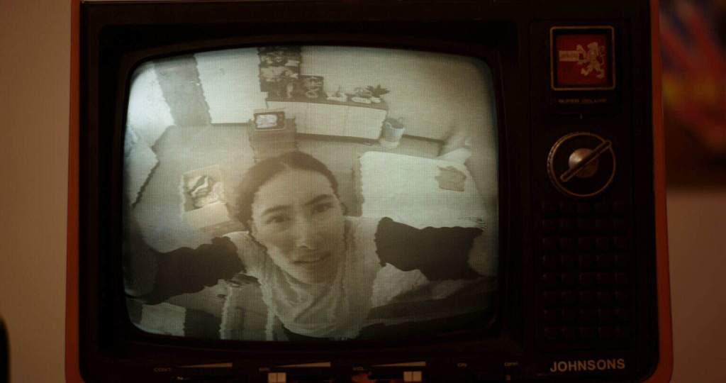 Woman on a vintage TV screen with static-warped image and retro controls.
