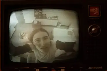 Woman on a vintage TV screen with static-warped image and retro controls.