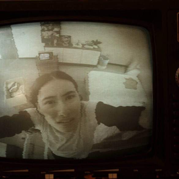 Woman on a vintage TV screen with static-warped image and retro controls.