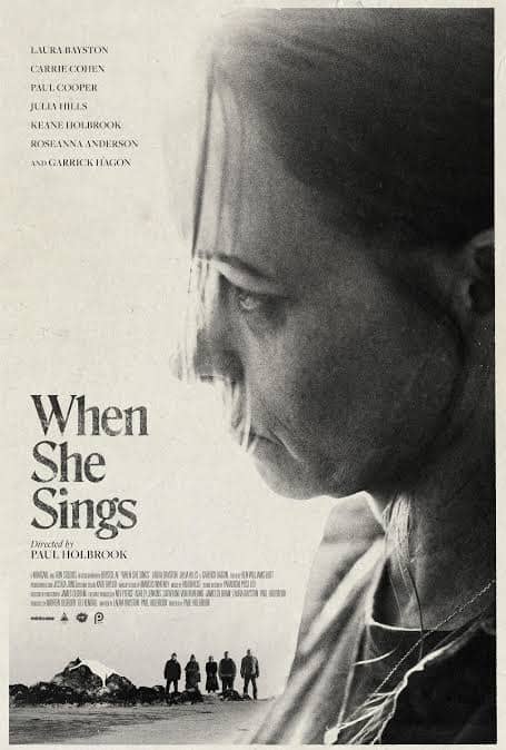 Close-up of a woman's face from the horror film 'When She Sings' with a dark, ominous background.